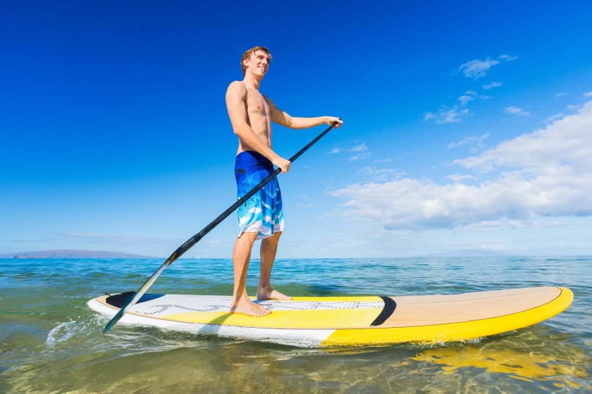 A man standing on a surfboard in the ocean